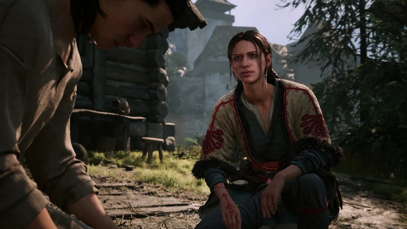 Anca sits beside Coen in a village during daylight