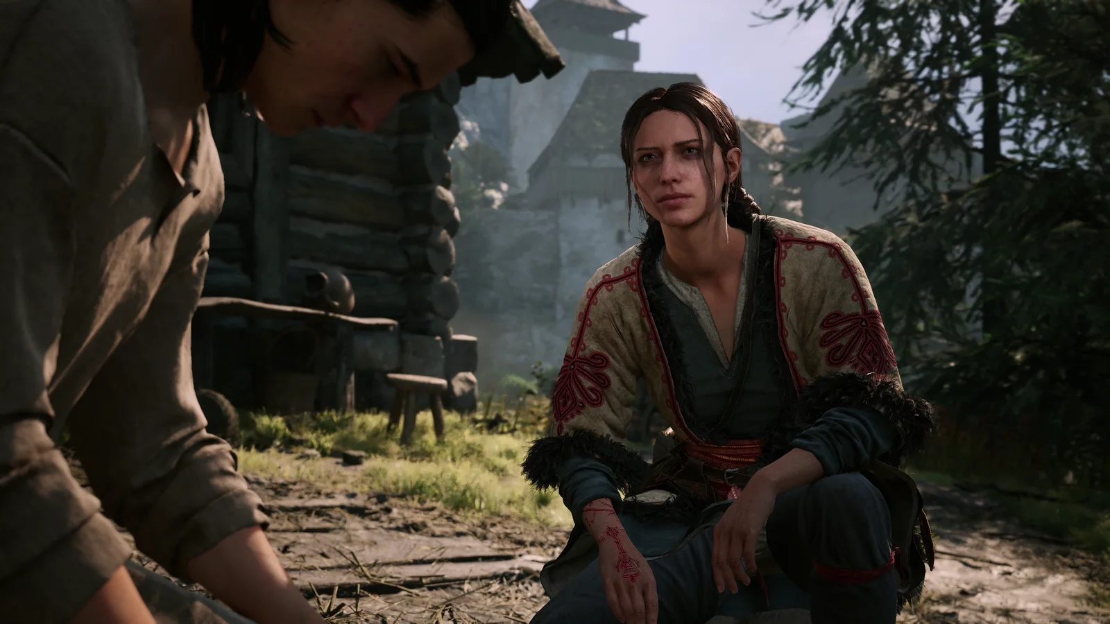 Anca sits beside Coen in a village during daylight